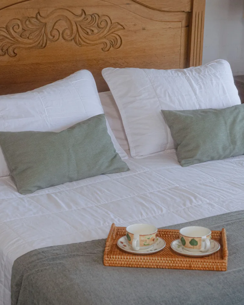 Cubrecama Charo blanco sobre una cama con bandeja de desayuno